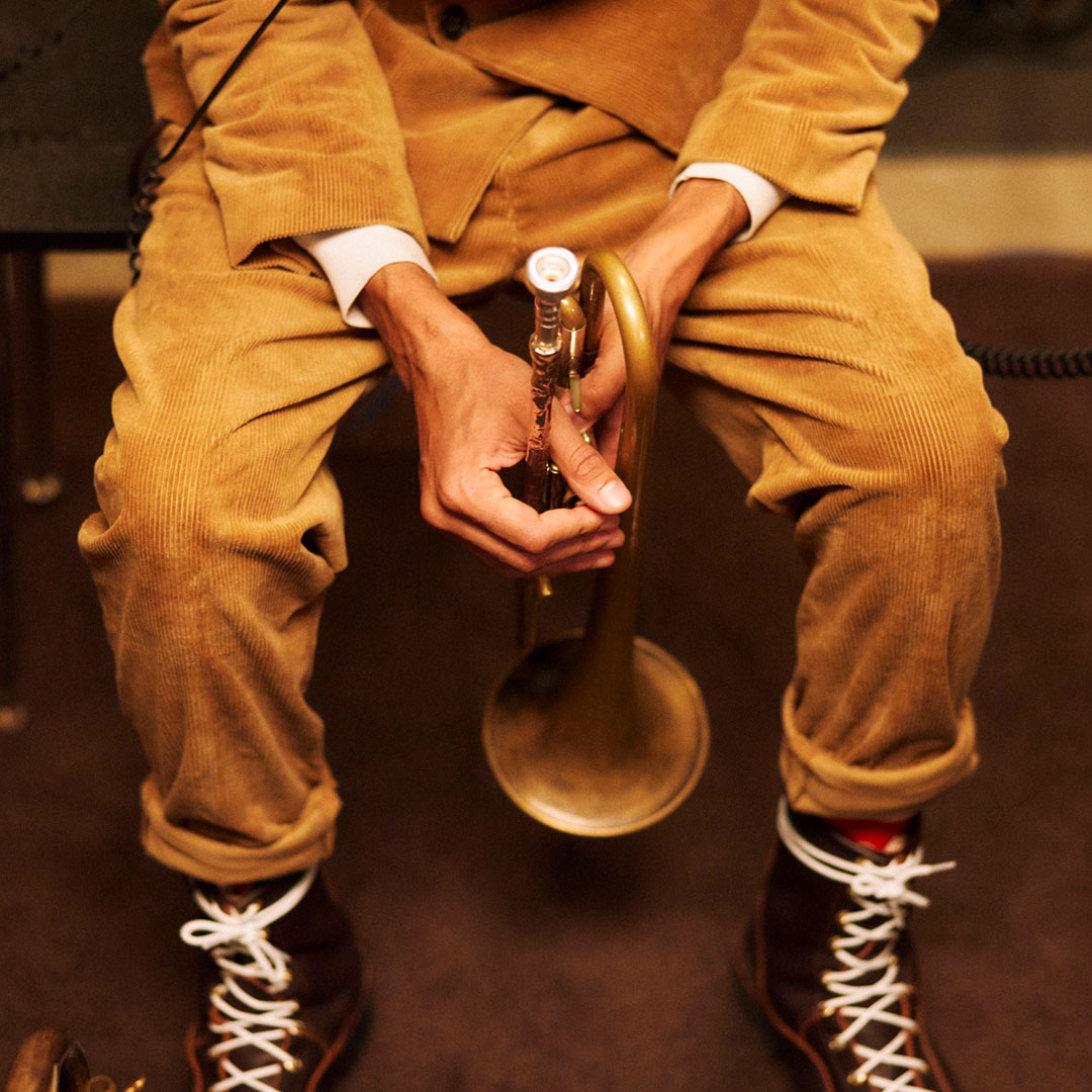 Man holding a trumpet between his legs